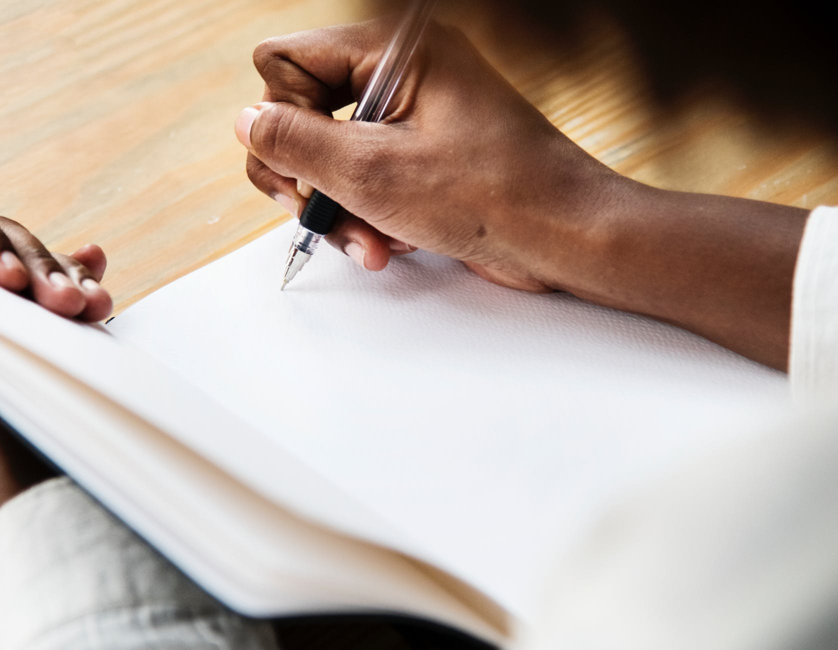 person uses pen on book