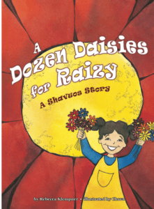 Raizy holds up her daisies in two hands while smiling broadly